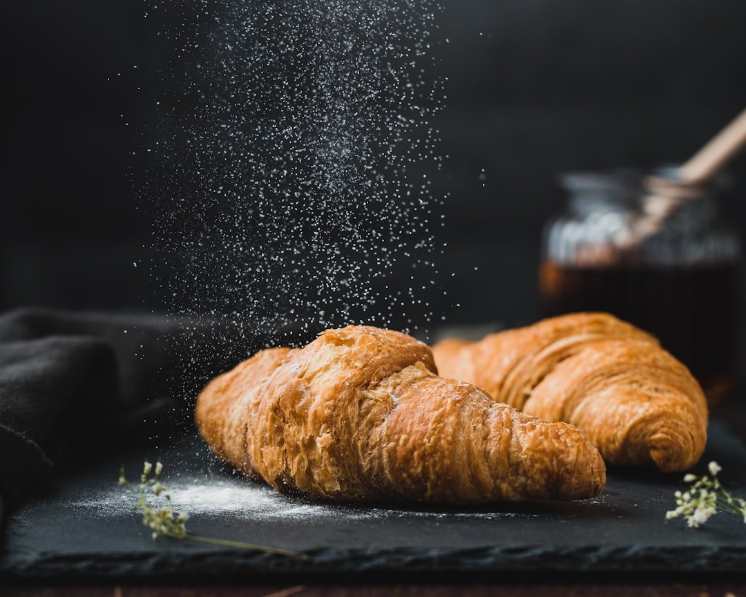 Croissant siendo espolvoreado